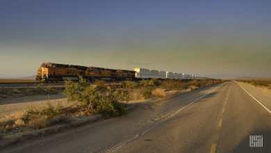A photograph of a BNSF train hauling intermodal containers across a field.