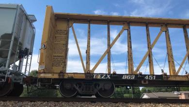 A photograph of a centerbeam car on a railroad track.