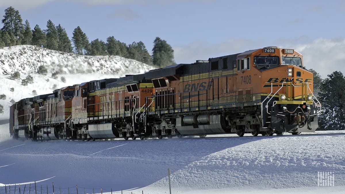 A photograph of a BNSF train traveling through a snowy field.