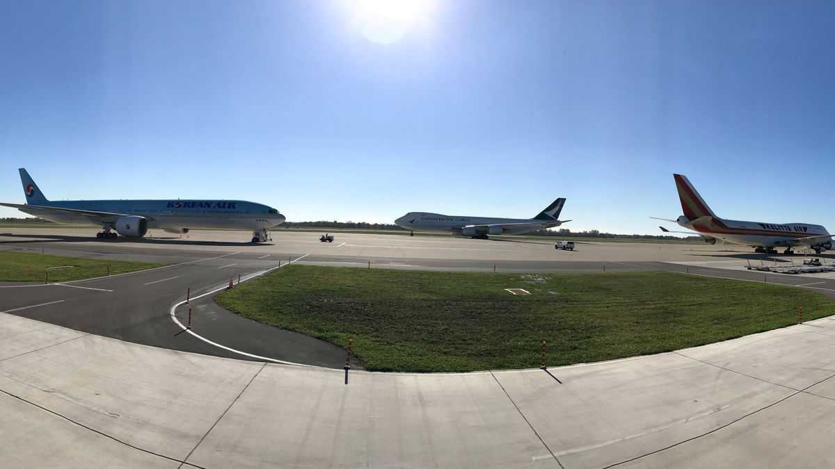 Landscape photo of three planes on tarmac on sunny day