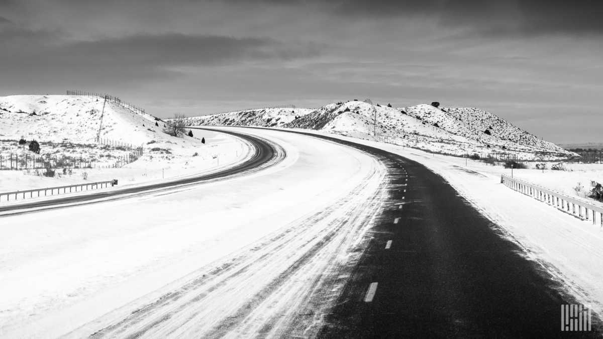 Snowy, frozen landscape along mountain highway.