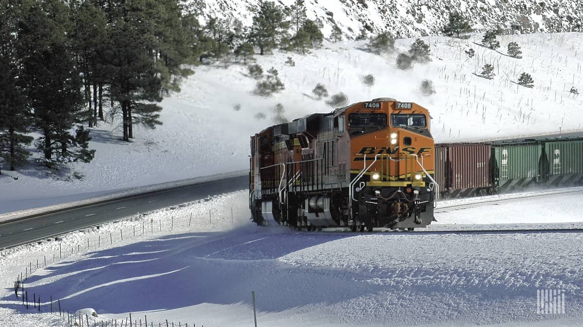 A photograph of a BNSF train traveling through a snowy field.