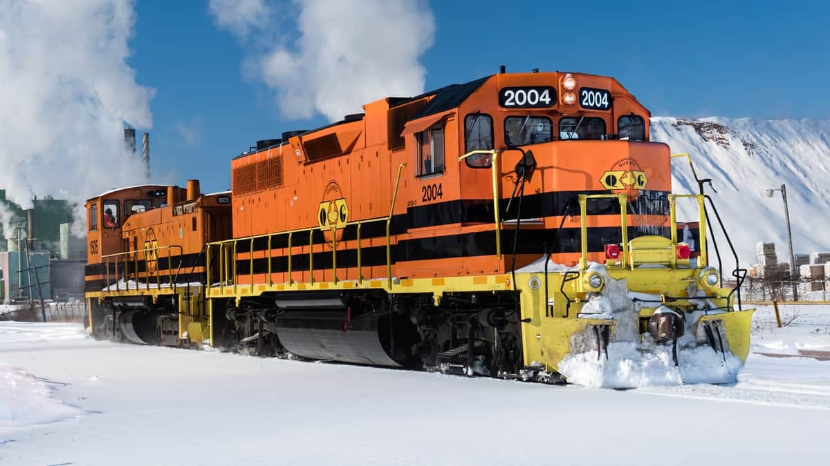 A photograph of a train traveling through the snow.