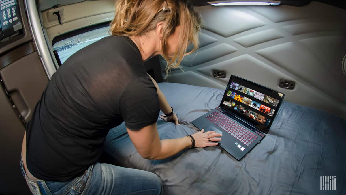 Truck driver looking up movies on her laptop.