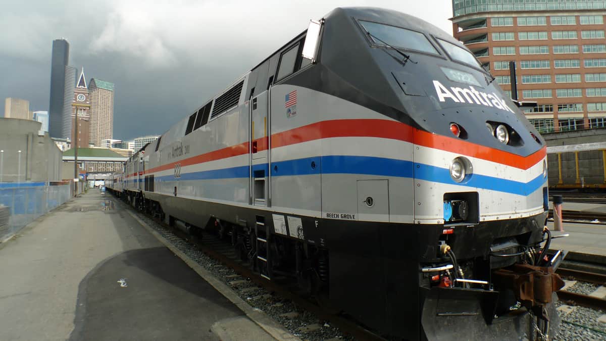 A photograph of an Amtrak train at a city station.