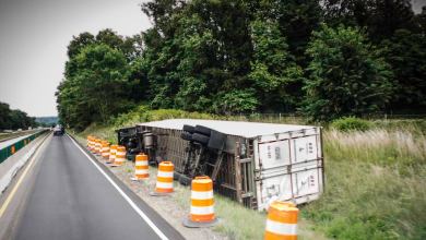 Tractor-trailer flipped on side of a highway.