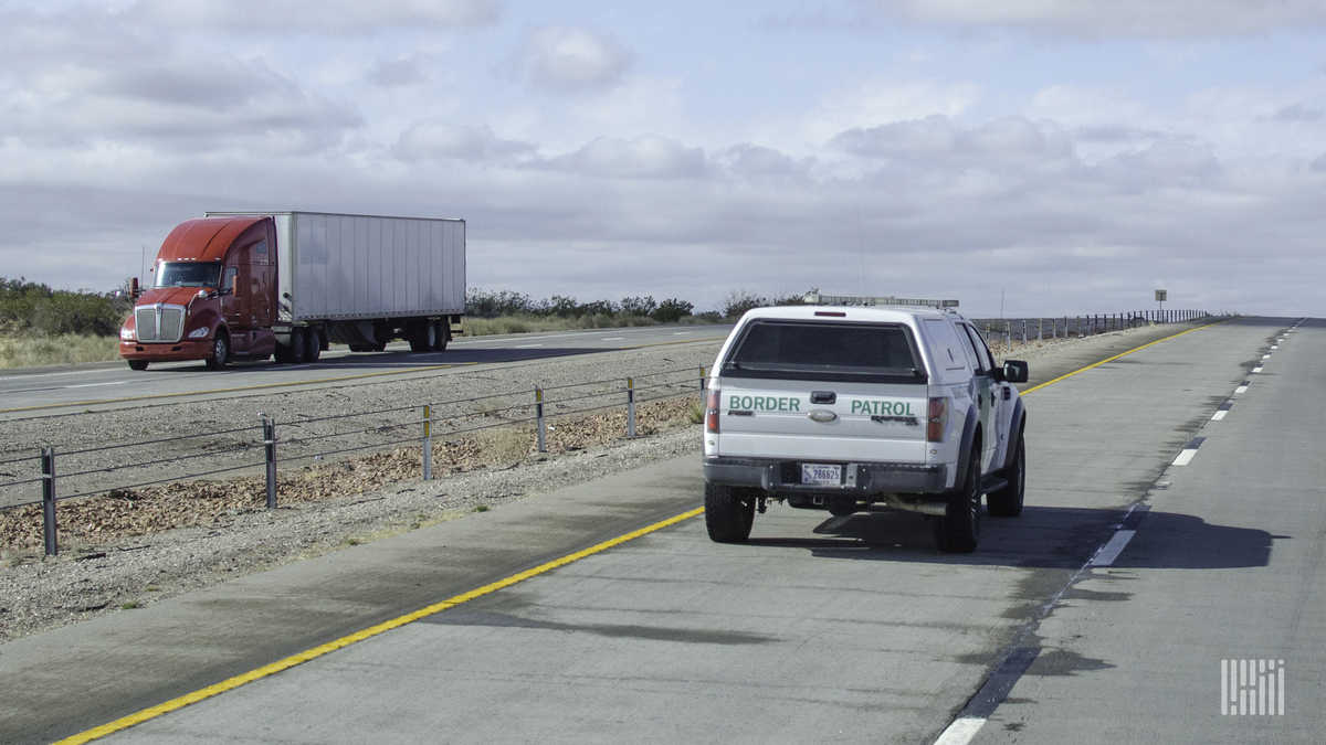 A truck and a border patrol vehicle pass near the U.S. Mexico Border. Cabotage regulations heavily restrict what trucks from Mexico and the Canada can do in the U.S.