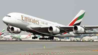A big, big Emirates A380 jumbo jet lifts off with front wheels off the runway.