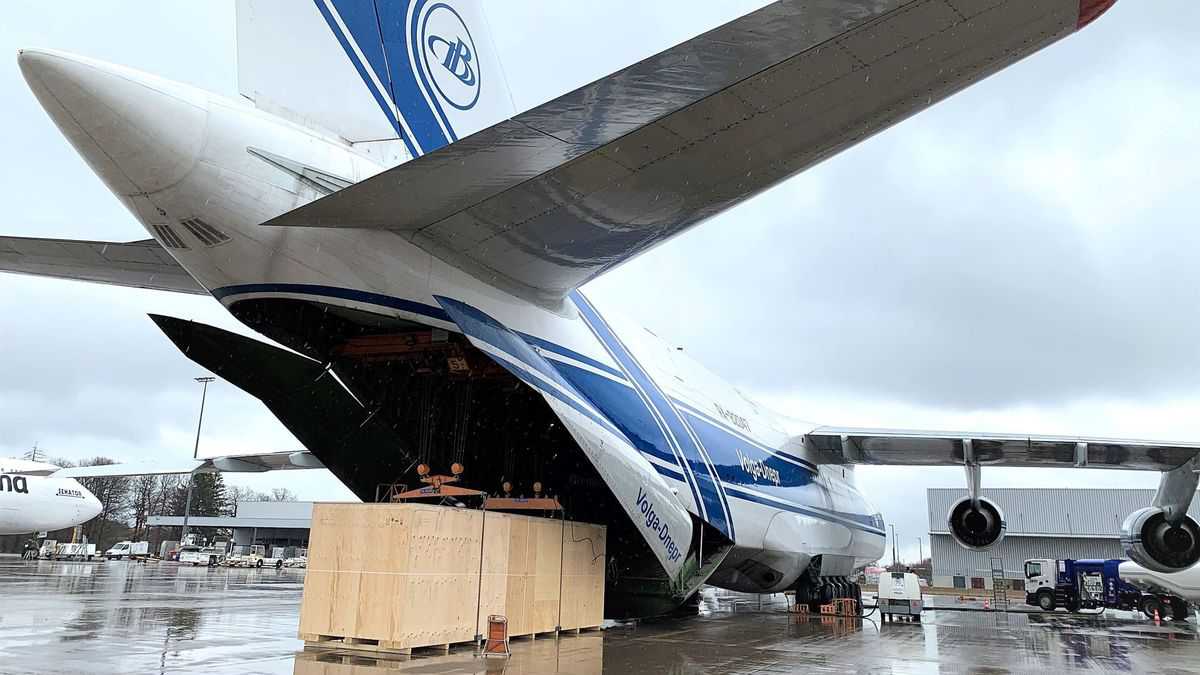 The open rear tail of a giant Russian cargo plane unloading a big crate.