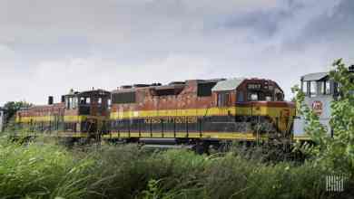 A photograph of Kansas City Southern train traveling through a grassy field.