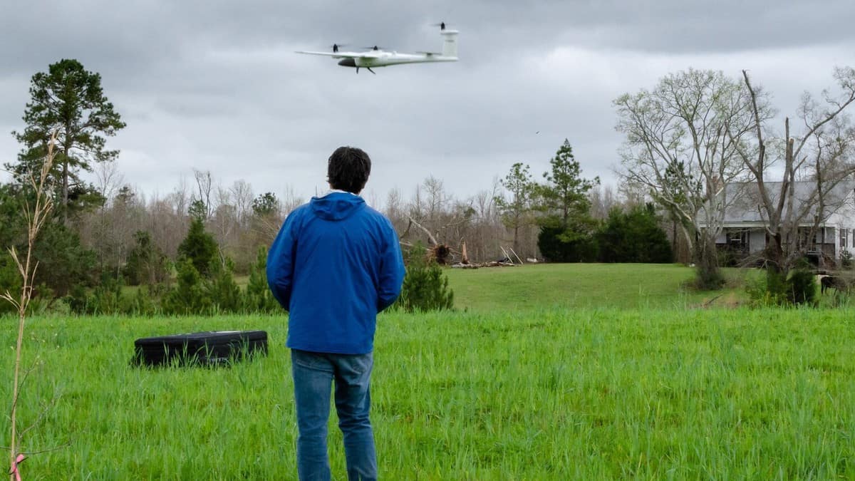 NOAA scientist launching a research drone to take aerial footage of tornado damage.