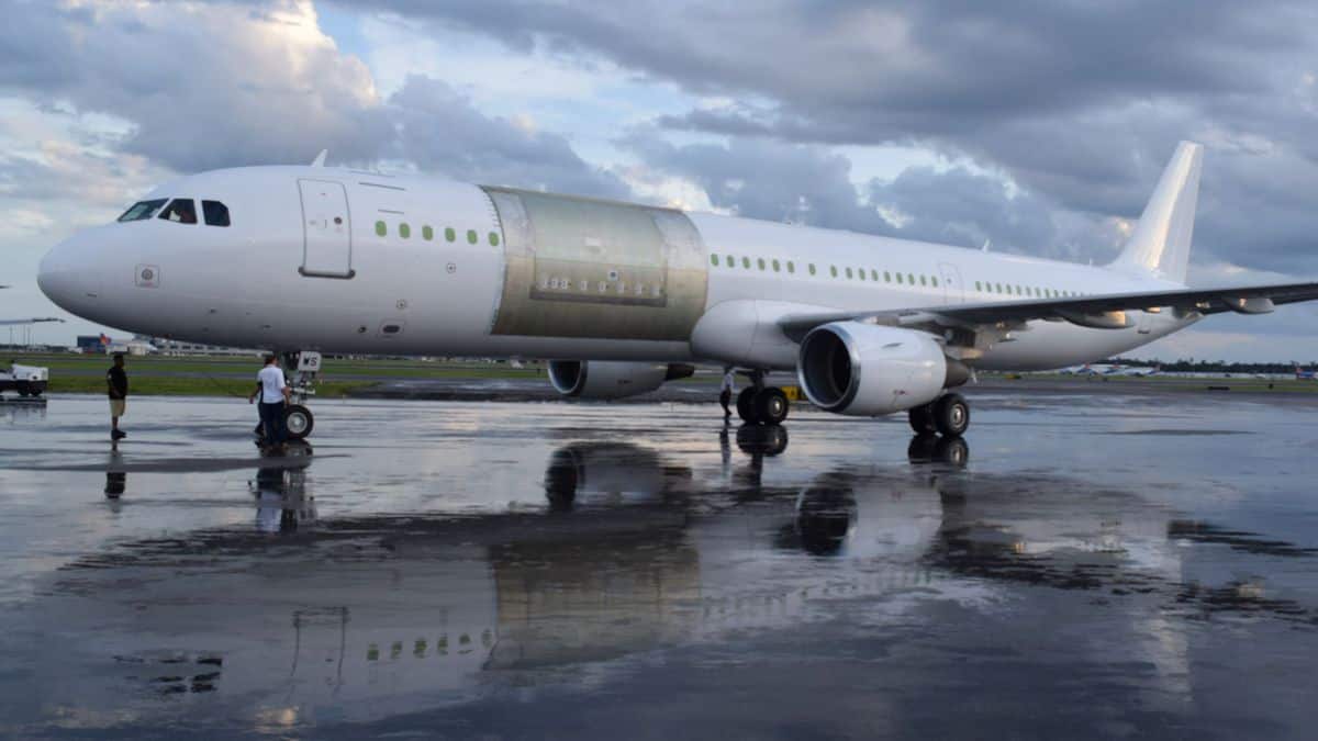 A white plane with no markings and an outline for cutting a large cargo door in side.