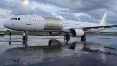 A white plane with no markings and an outline for cutting a large cargo door in side.