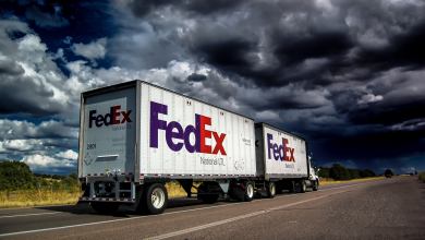 A white FedEx Freight truck pulling a double trailer. View from the rear side.