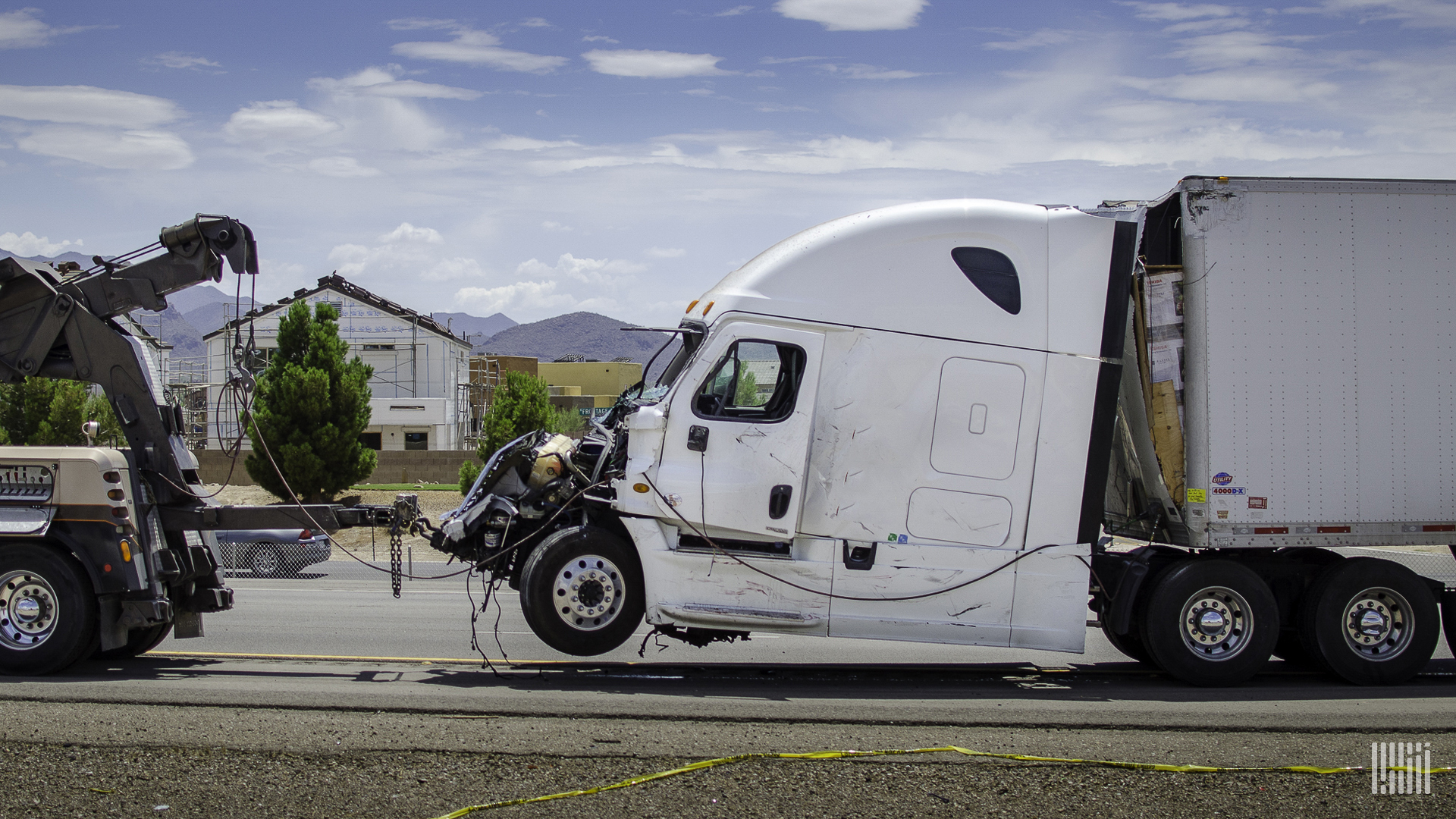 Damaged tractor-trailer being towed.