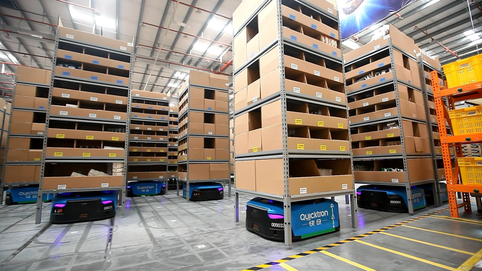 Small robots move bins of goods in an automated warehouse.