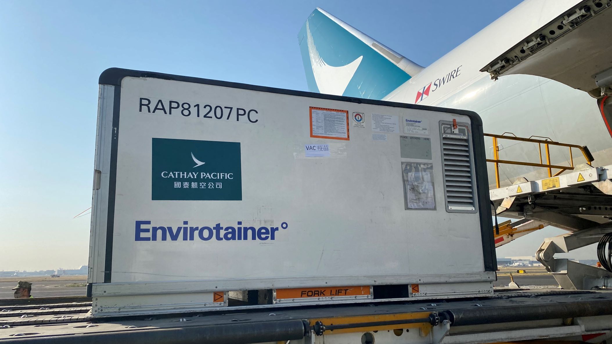 A refrigerated container is ready to be lifted up to the side door of cargo plane.