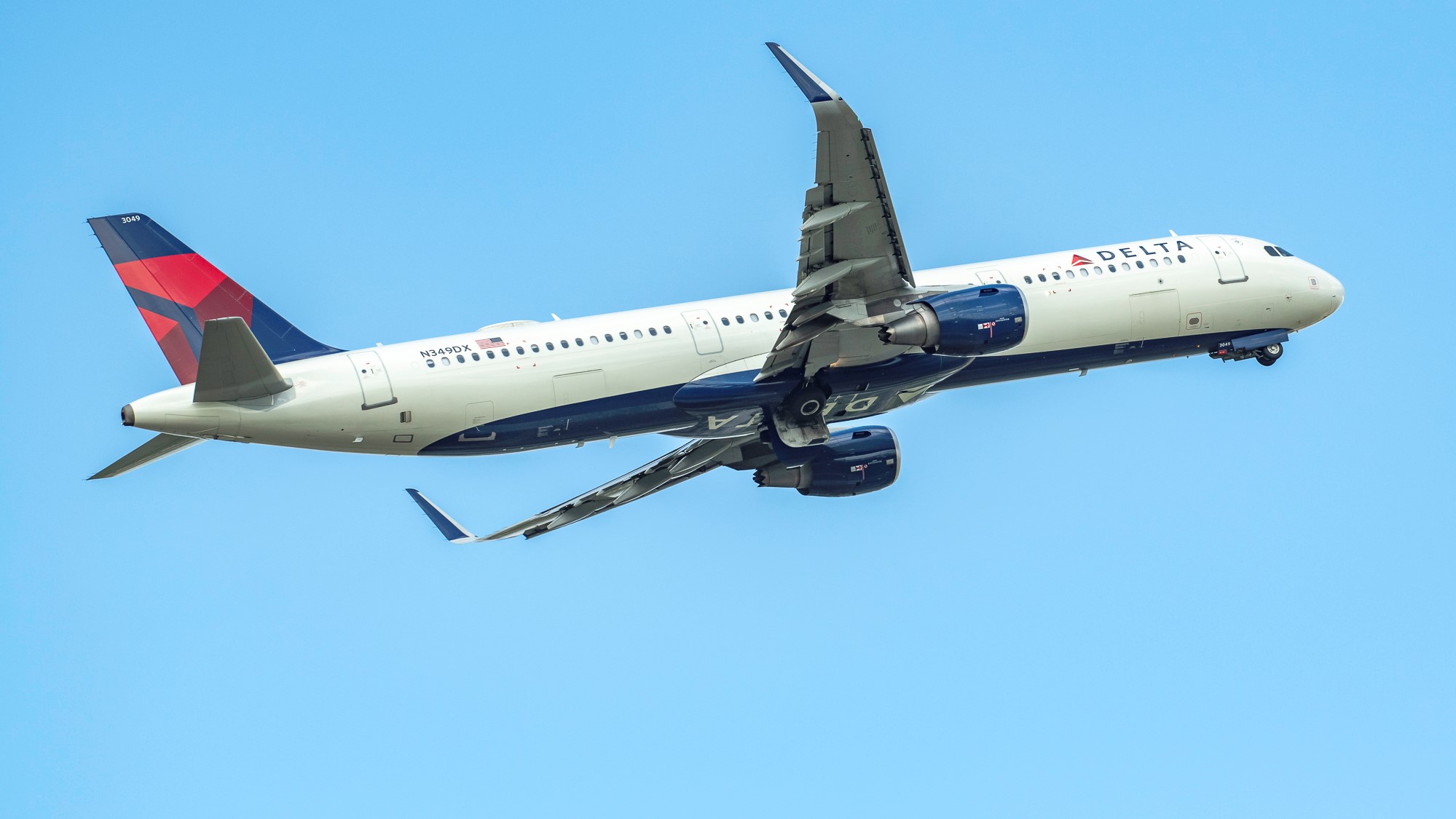 A Delta jet banking in the blue sky, view from underneath.