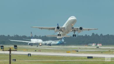 A white plane takes off with view facing the aircraft.