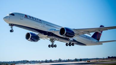A white Delta jet takes off with wheels still down.