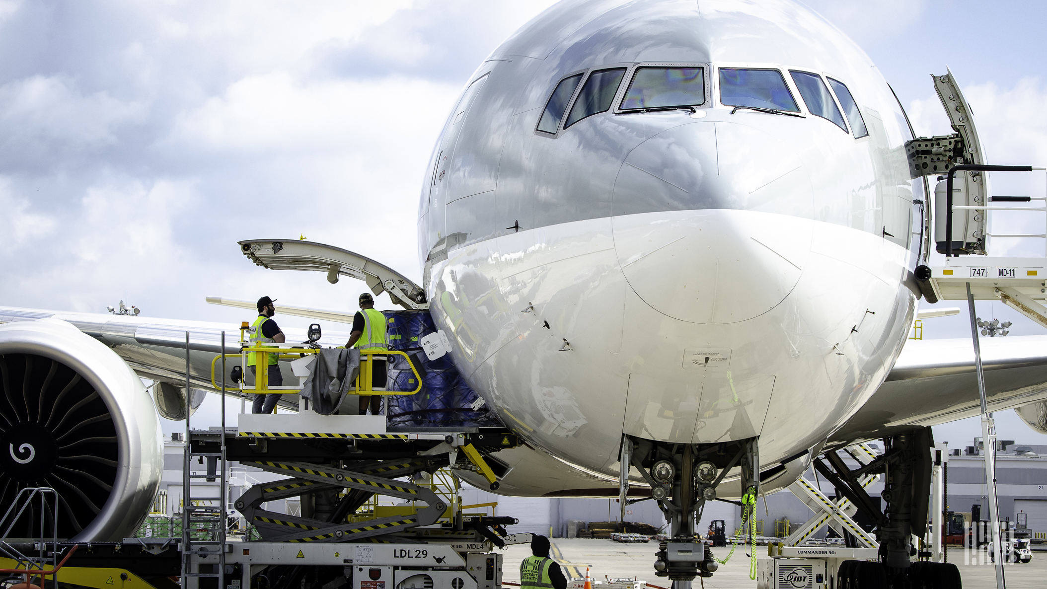 Crew loading/unloading cargo onto a jet.