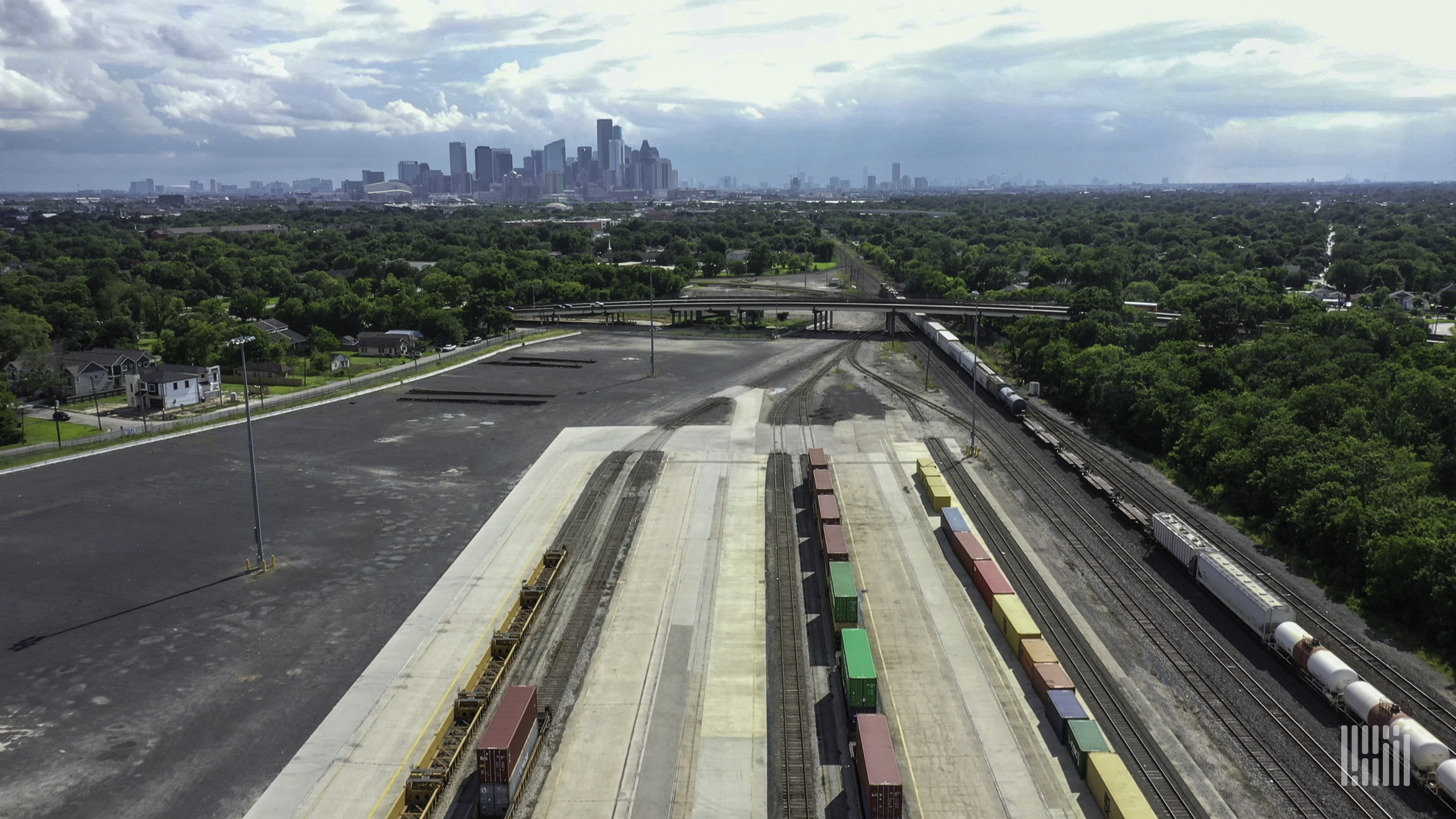 A photograph of a rail yard with a city in the distance.