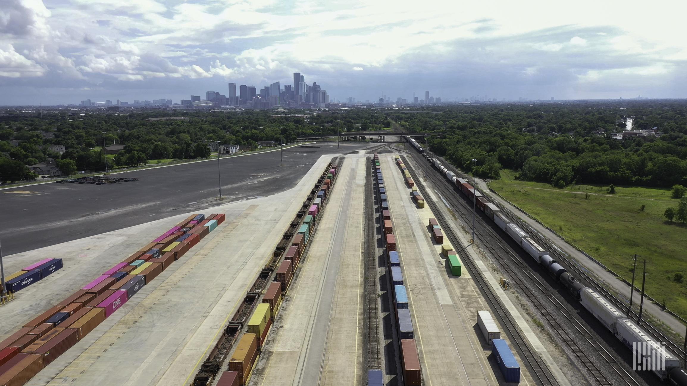 An aerial photograph of a rail yard with parked intermodal containers lined up in rows.