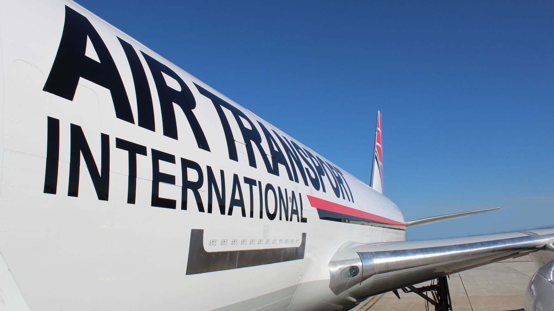 Close up side view of a white plane, with logo Air Transport International.