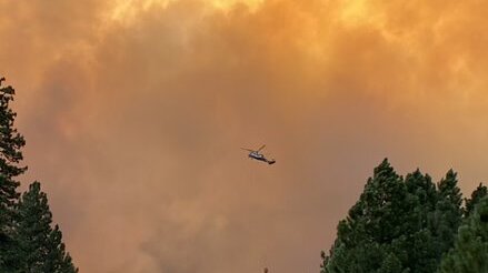 Helicopter dropping water onto the Dixie fire in northern California, Aug. 13, 2021.