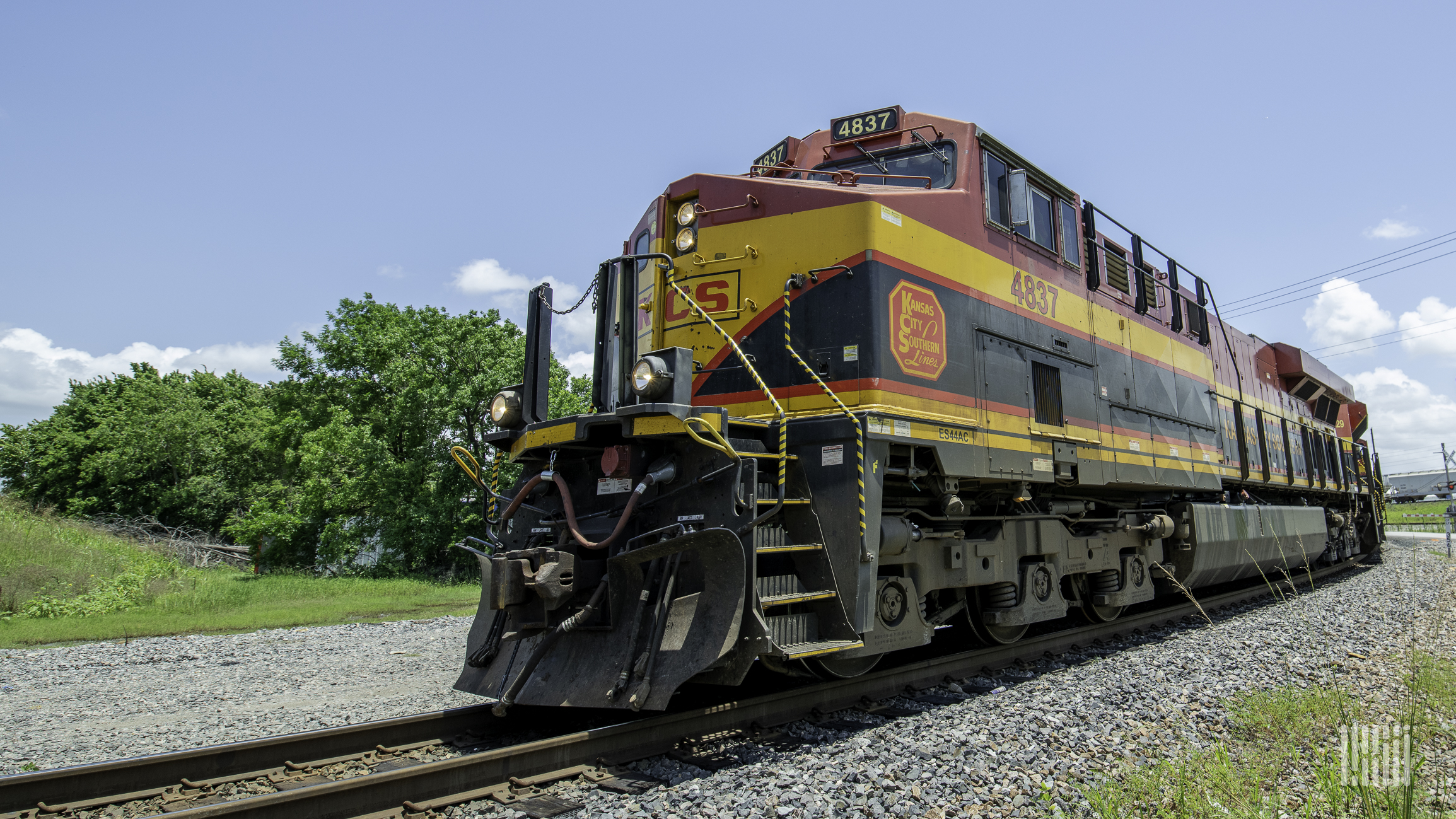 A photograph of a Kansas City Southern train turning around the curve.