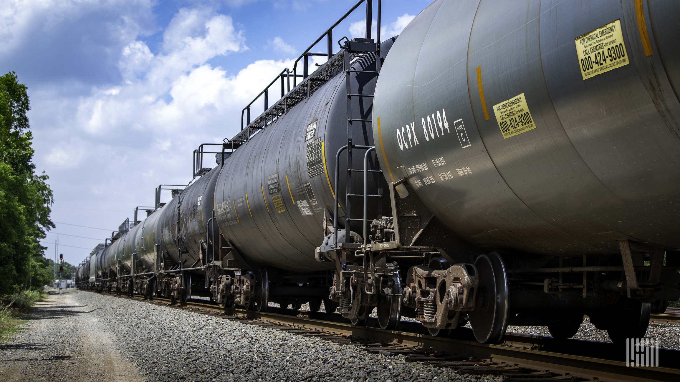 A photograph of tank cars parked in a rail yard.