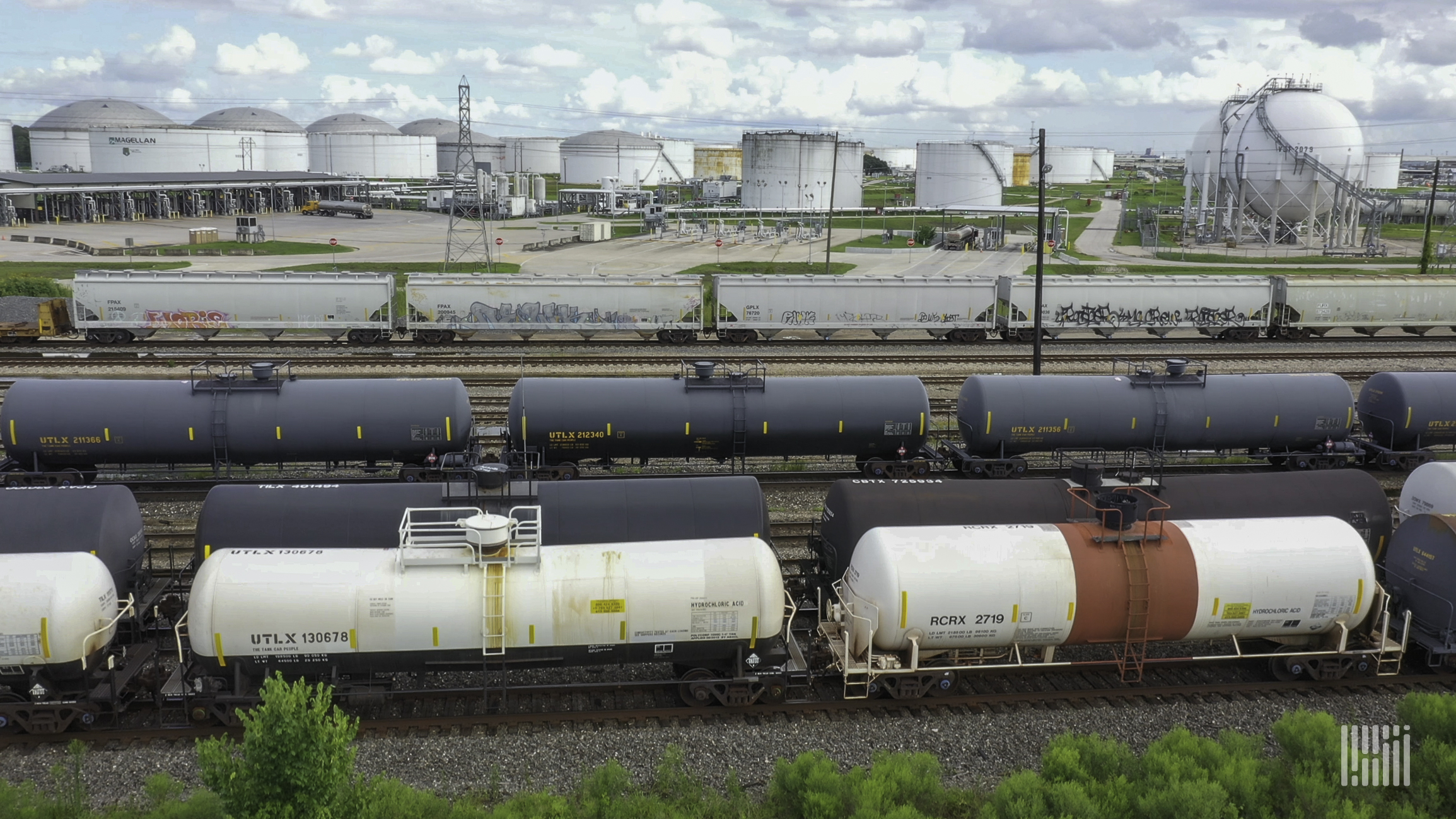 A photograph of tank cars parked in a rail yard.