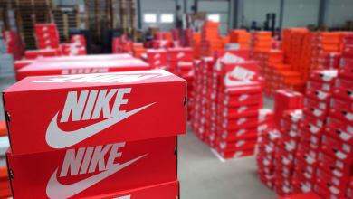 Stacks of red Nike shoe boxes in a warehouse.