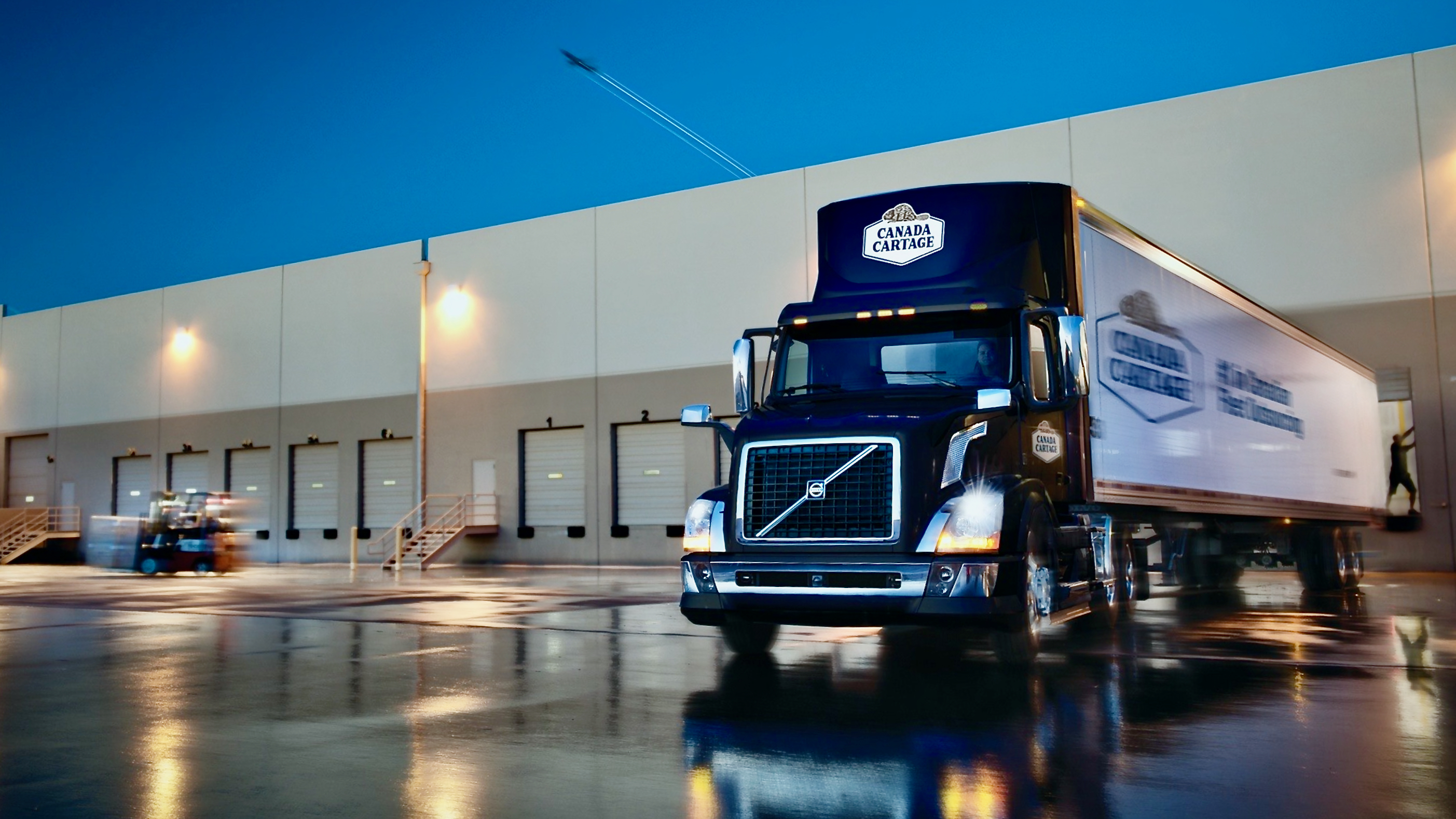 A truck from Canada Cartage exits a loading dock.