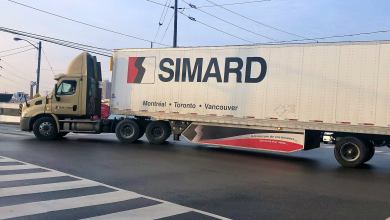 A tractor-trailer logo SIMARD makes a turn on a street to illustrate an article about the Canadian election.