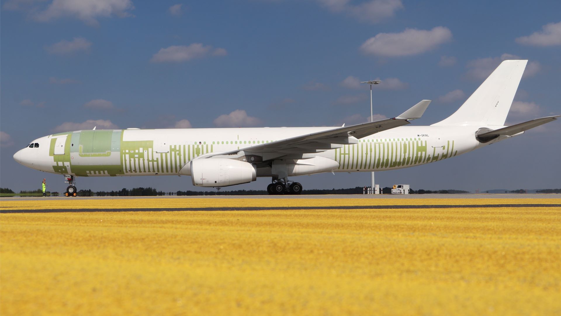 A large plane with patches on the fuselage where modifications were made for cargo configuration.