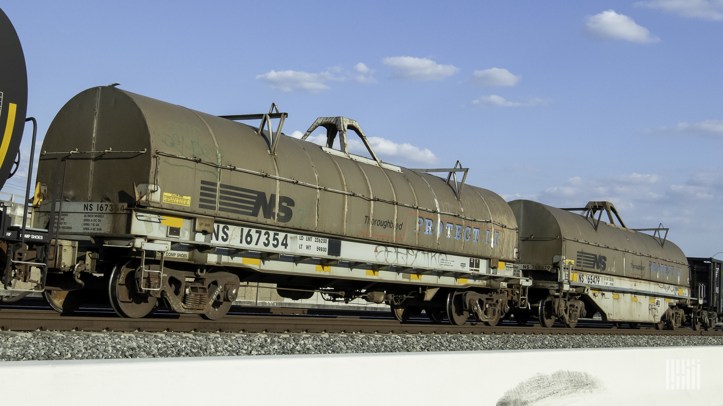 A photopgraph of tank cars parked in a rail yard.