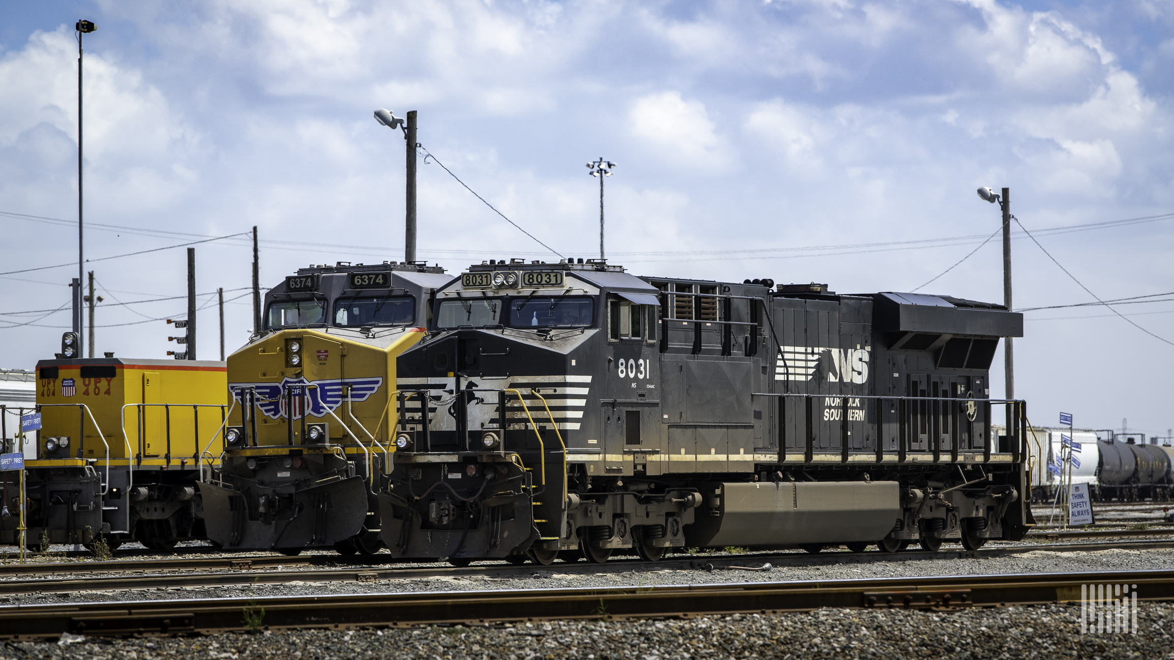 A photograph of a Norfolk Southern train parked next to a Union Pacific train.