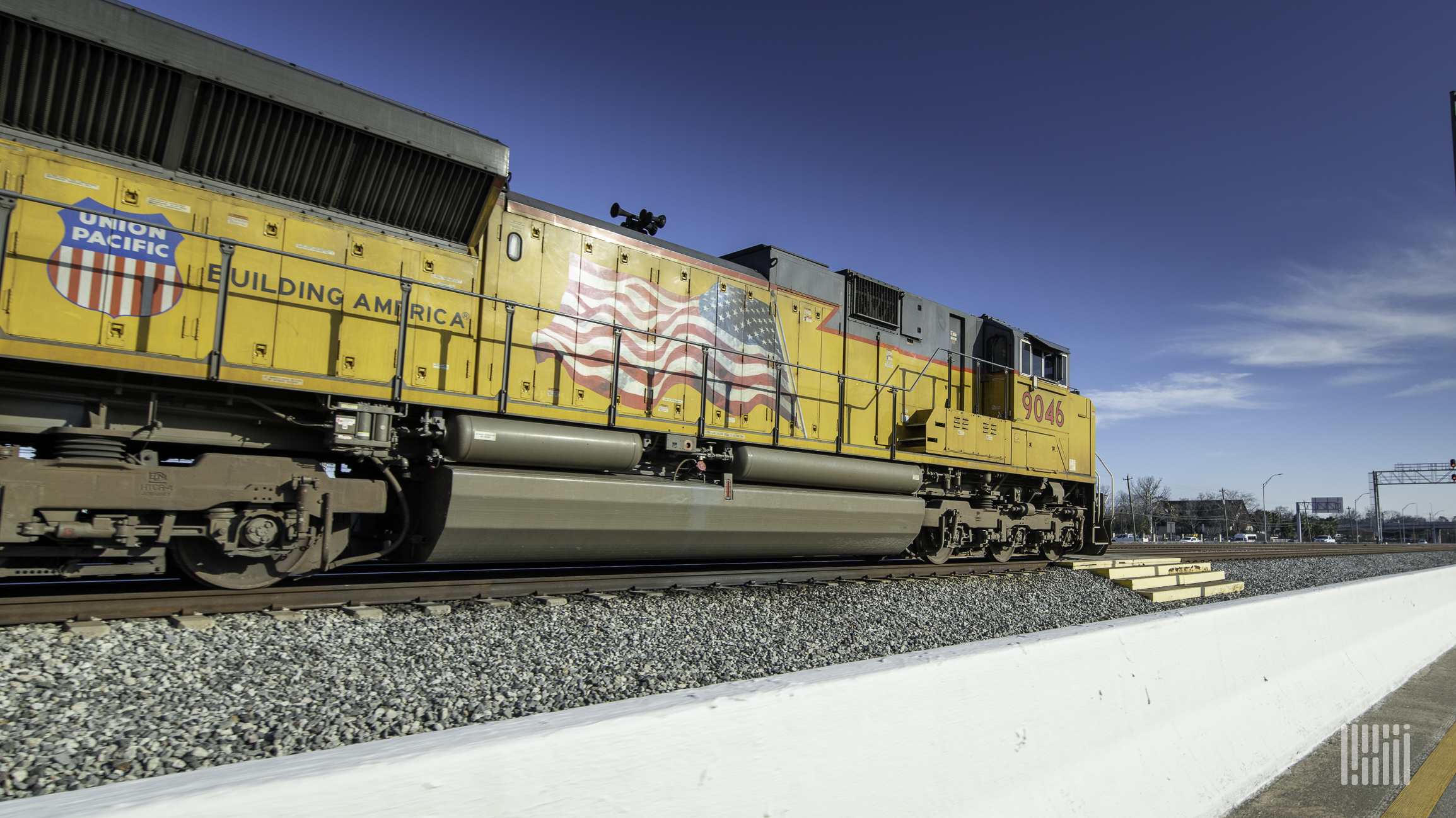 A photograph of a Union Pacific train rolling down a rail yard.