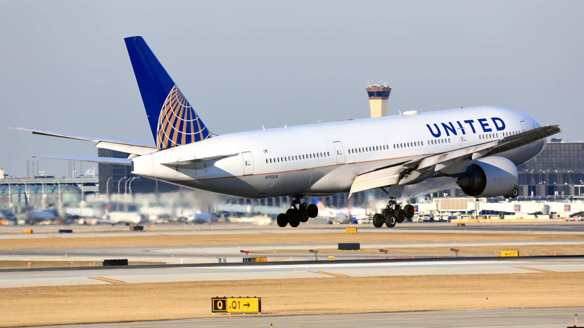 A white United Airlines jet takes off, view from the rear.