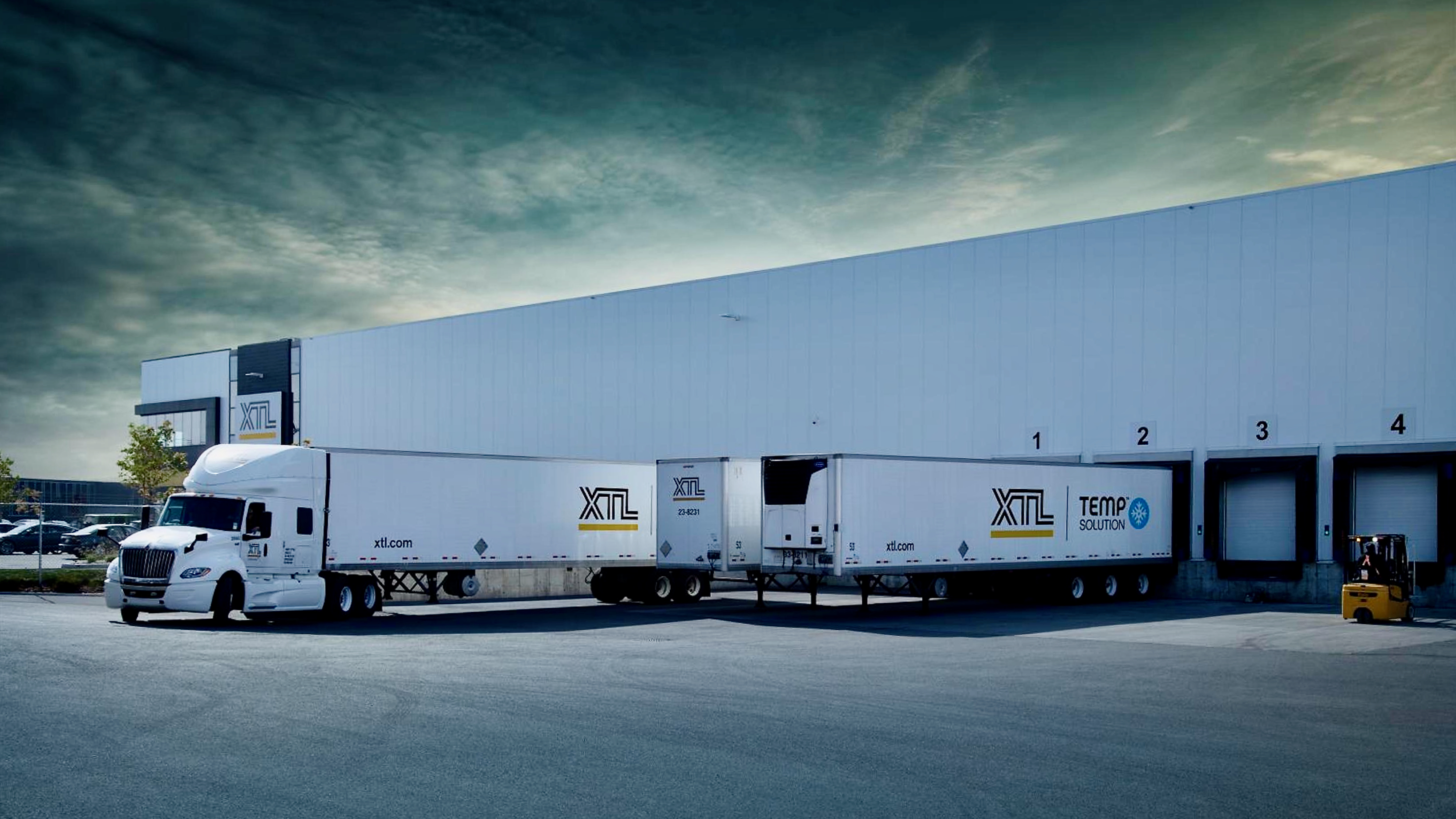 Tractor-trailers of XTL at a company load facility.