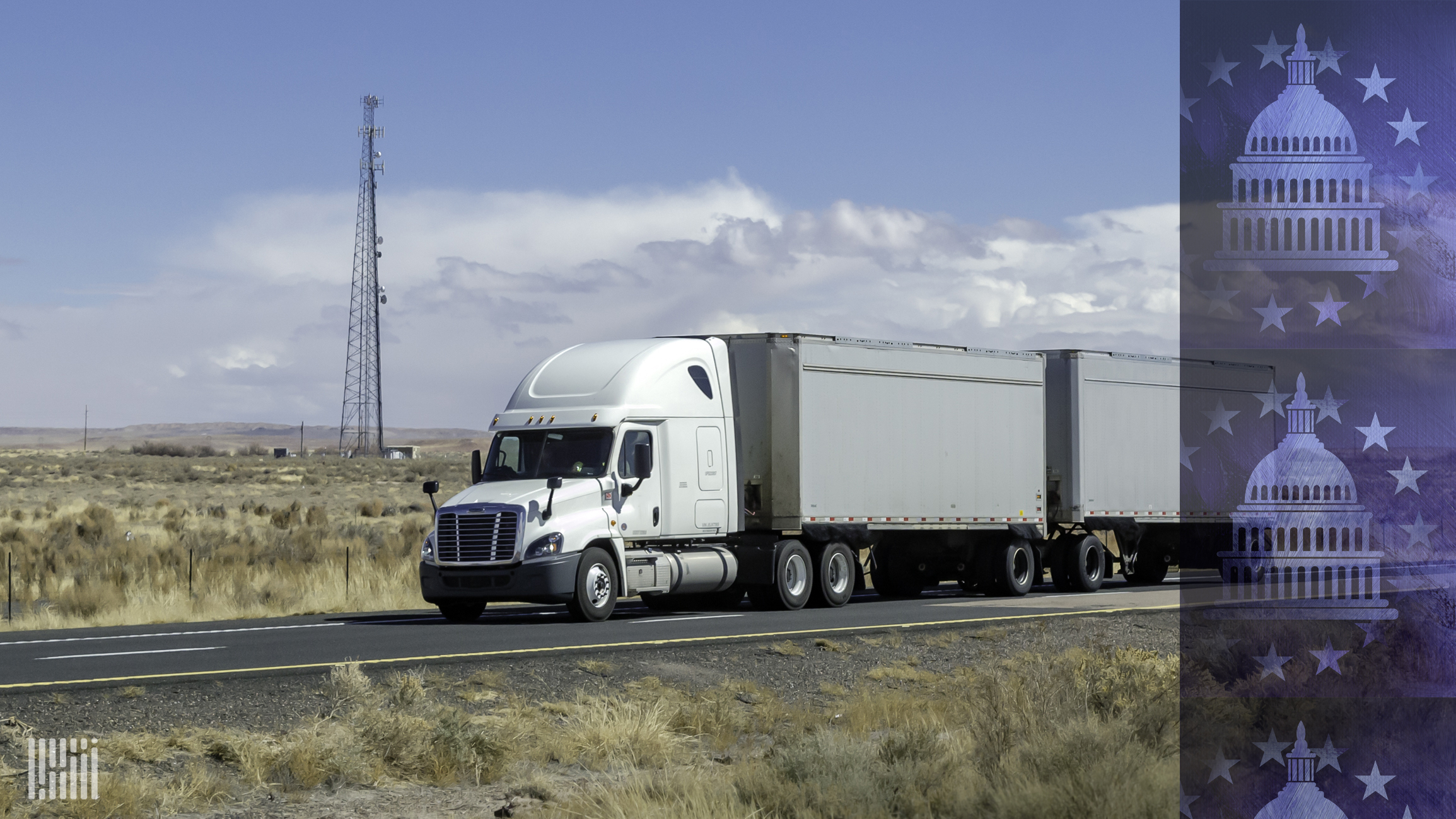 Tractor-trailer on a highway with communications towers in the background.