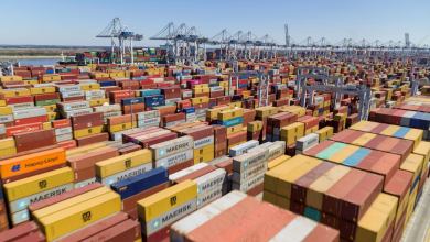 Stacks and stacks of orange shipping containers at a port.