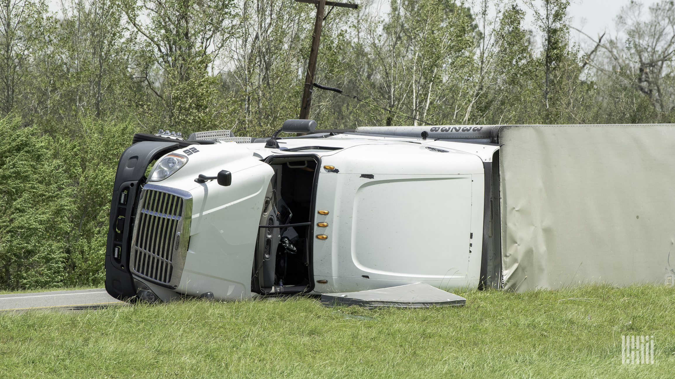 Tractor-trailer tipped over on side of a road.