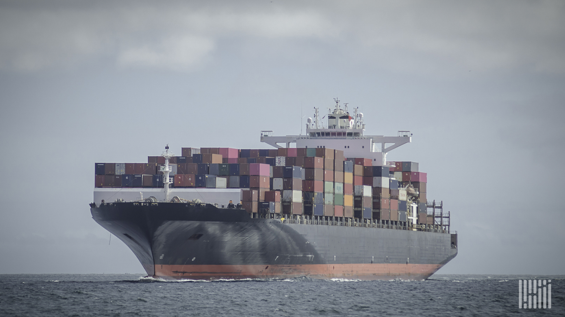 A container ship travels on the water to illustrate an article about cybercriminals selling access to shipping firms