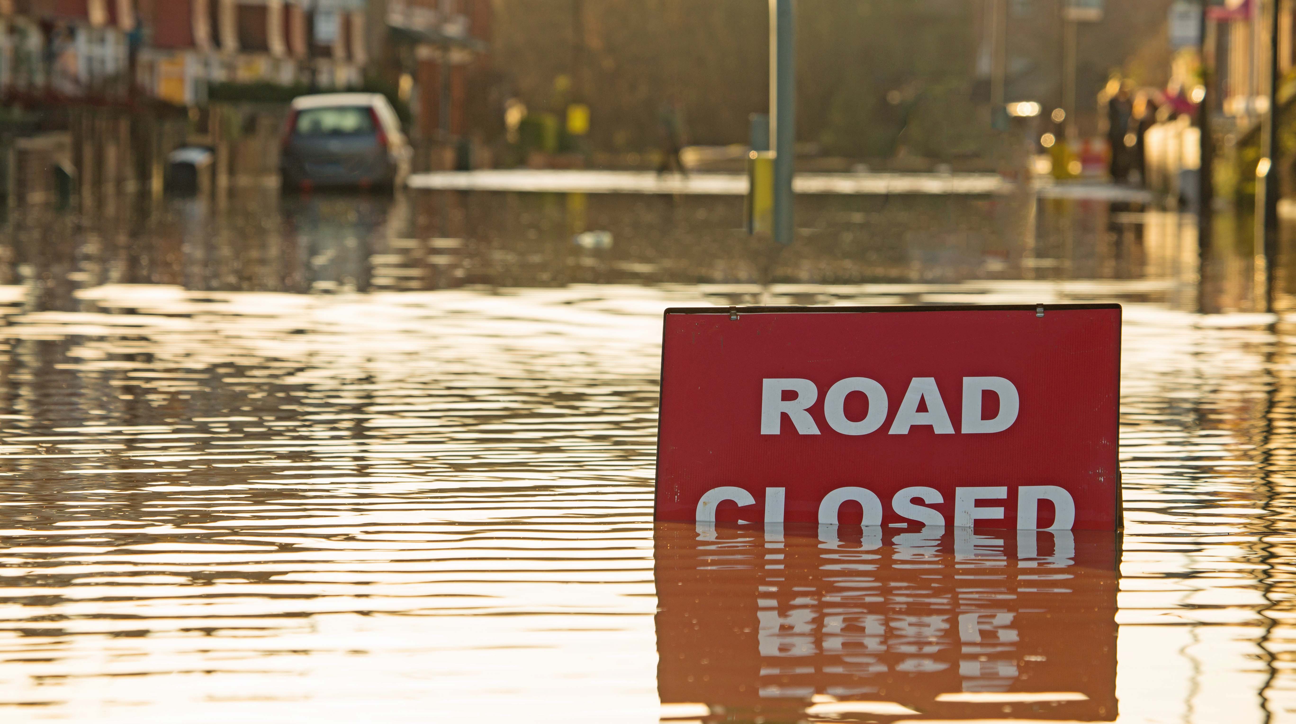 Flooded road with "Road Closed" sign.