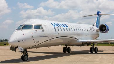 A small white United Express jet, close up from near the front nose.