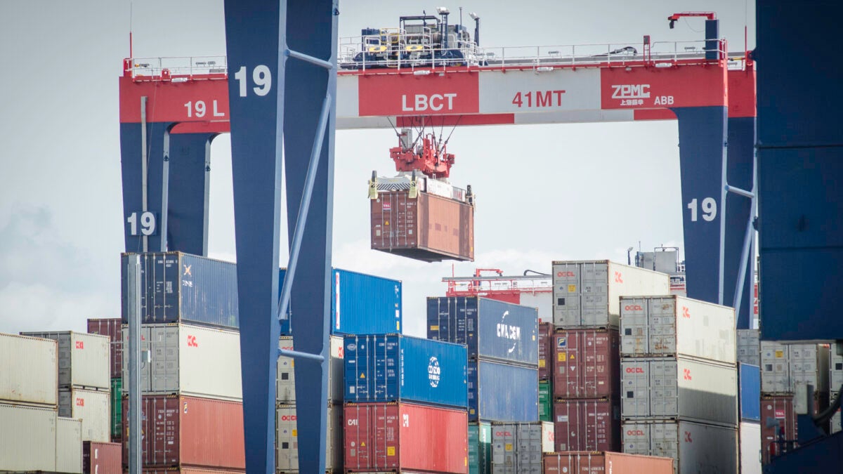 Gantry cranes lifting containers onto stacks at a port.