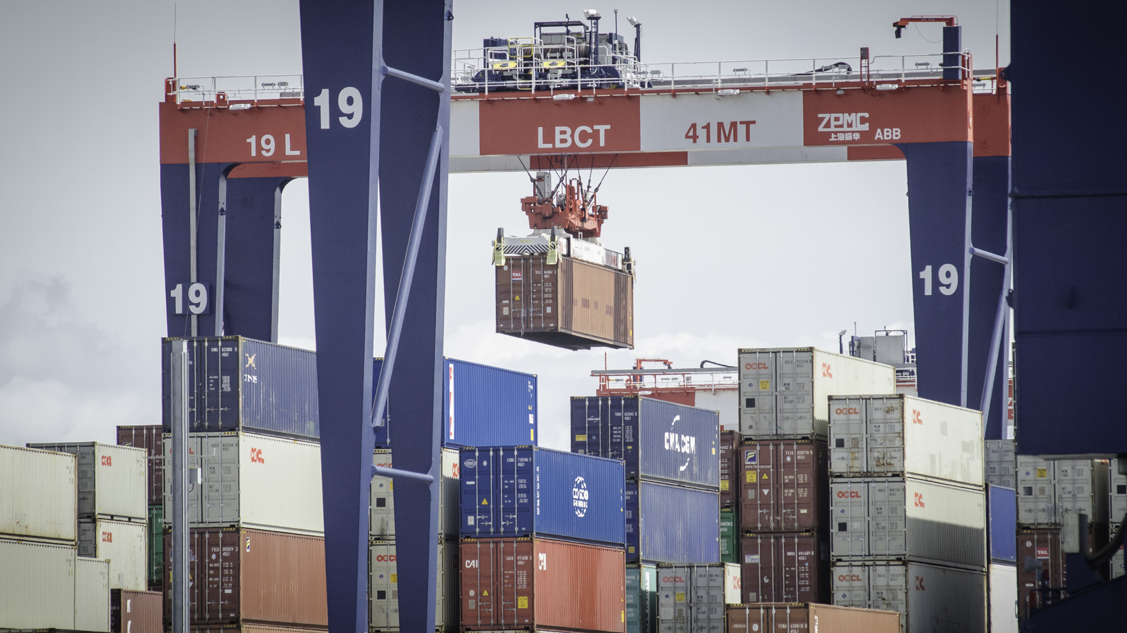 Gantry cranes lifting containers onto stacks at a port.