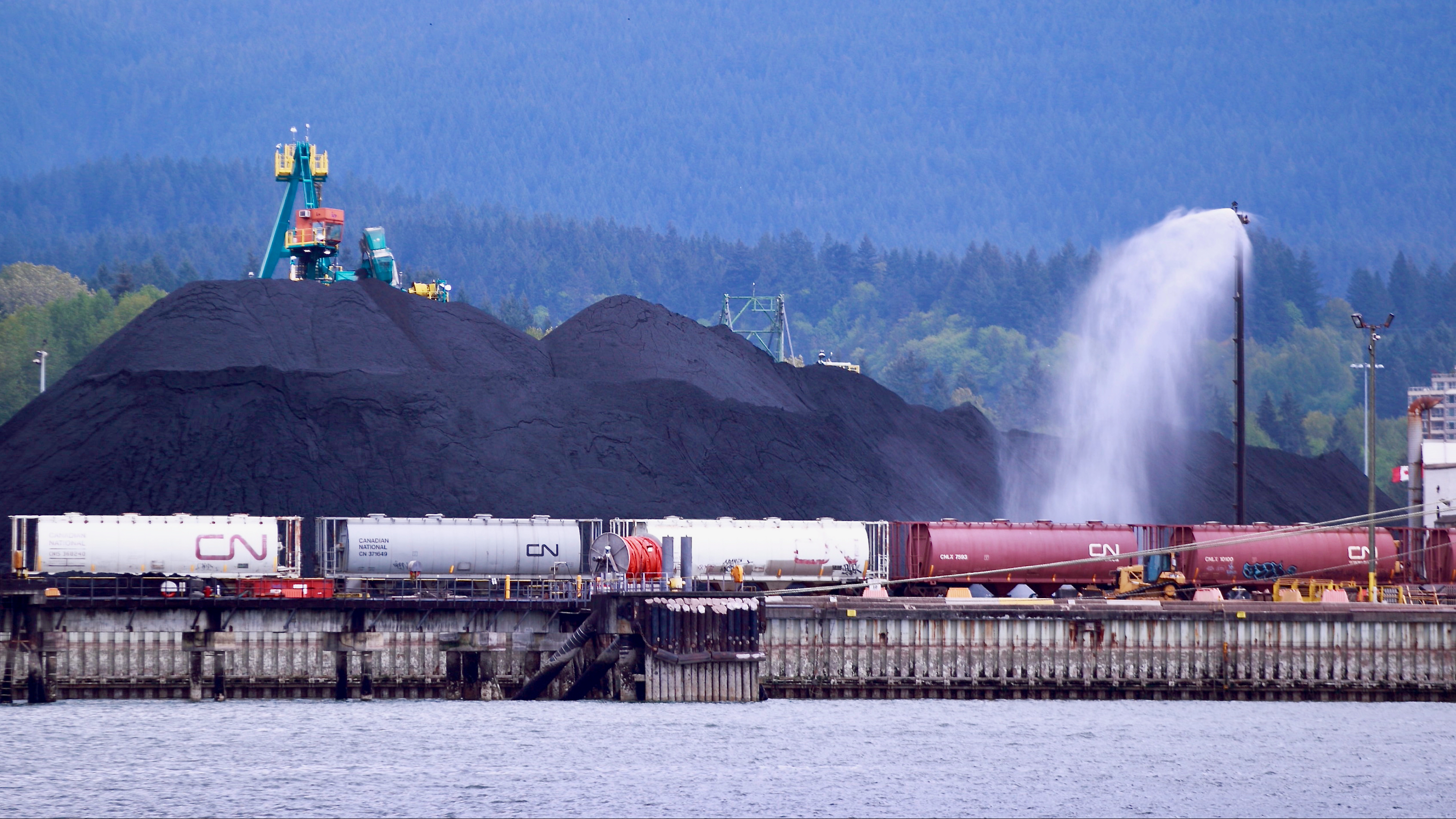 CN trains at the Port of Vancouver Neptune terminal with coal in the background.